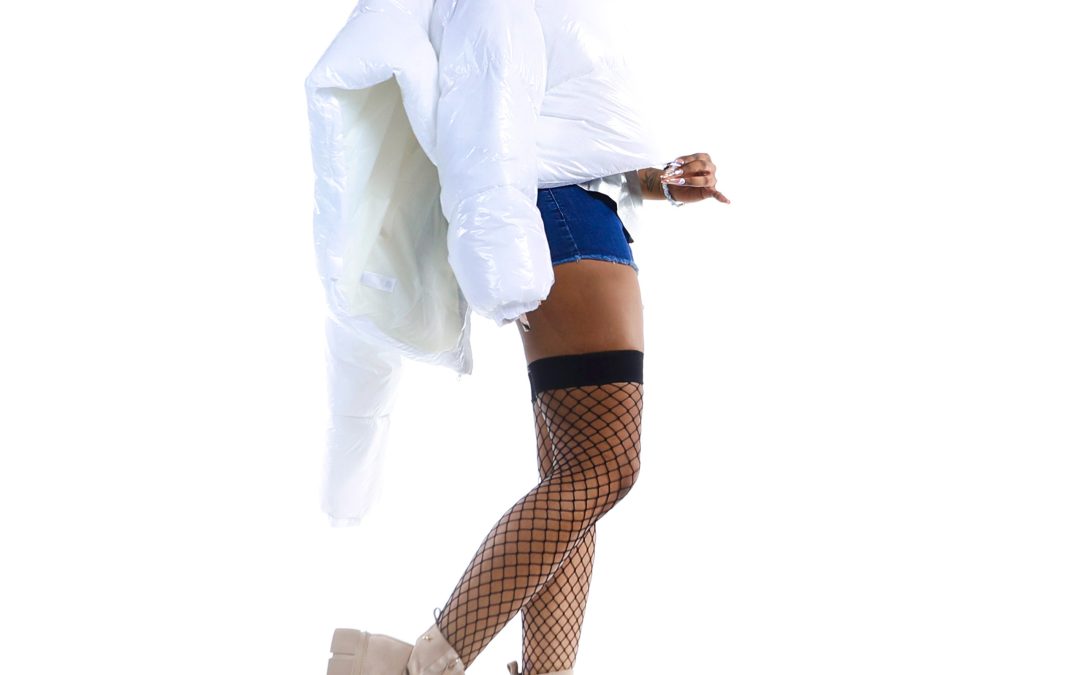 A woman in a white coat and blue shorts